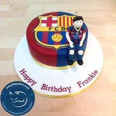 a birthday cake with a figurine of a soccer player sitting on top of it