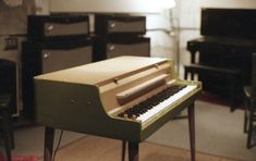 an old piano sitting on top of a hard wood floor next to other musical instruments