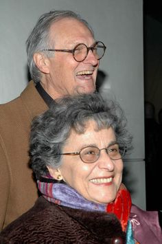 an older man and woman are smiling for the camera