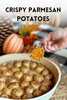 crispy parmesan potatoes in a white bowl with a hand holding a cracker over it