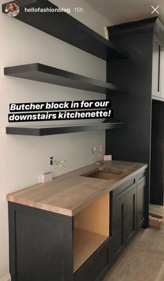 a kitchen with black cabinets and wooden counter tops in front of a white wall that reads, butcher block in for our downstark kitchenette