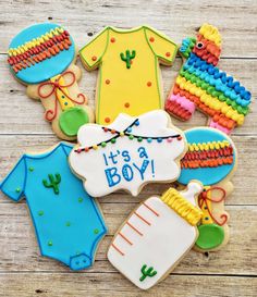 decorated baby shower cookies with its a boy on it's bodysuit and booties