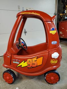 a red toy car with the number 95 on it's front tire and steering wheel