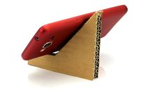 a red phone sitting on top of a piece of cardboard