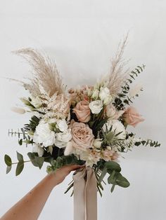 someone holding a bouquet of flowers in their hand