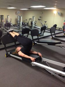 a man is doing an exercise on a rowing machine in a gym with other equipment