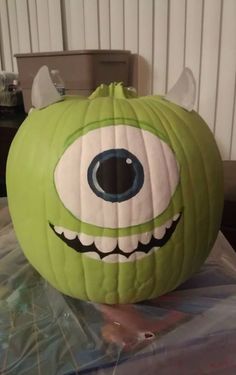 a green pumpkin with an evil face painted on it