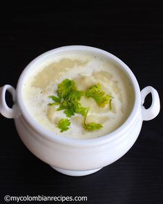 a white bowl filled with soup and garnished with cilantro