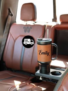 a coffee cup sitting in the back seat of a car with an emax sticker on it