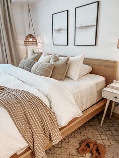 a bed sitting in a bedroom next to two framed pictures on the wall above it