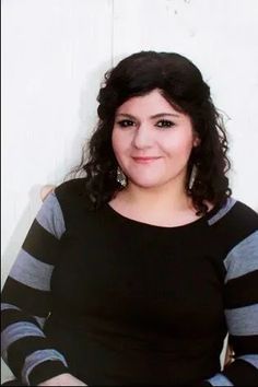 a woman in black and grey shirt posing for the camera