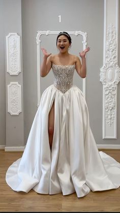 a woman in a white dress is standing on the floor with her legs crossed and hands out