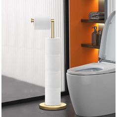 a white toilet sitting in a bathroom next to a wall mounted toilet paper dispenser