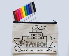 pencils are sticking out of a zippered bag with a boat drawn on it