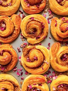 there are many different types of pastries on the trays with rose petals around them