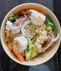 a bowl filled with rice and shrimp on top of a table