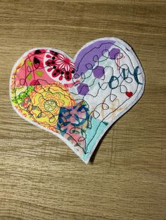 two heart shaped patches sitting on top of a wooden table