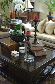 a living room filled with lots of furniture and flowers on top of a coffee table