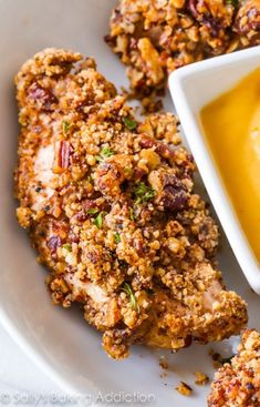 two pieces of fried chicken on a plate with mustard