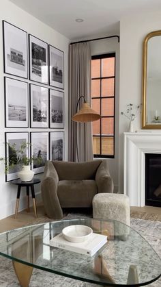 a living room with pictures on the wall and a glass table in front of it