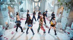 a group of people dancing in a room with flowers on the floor and one person holding a disco ball