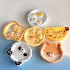 five small animal shaped dishes on a table