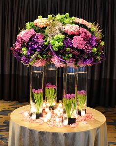 flowers and candles are arranged in vases on a table