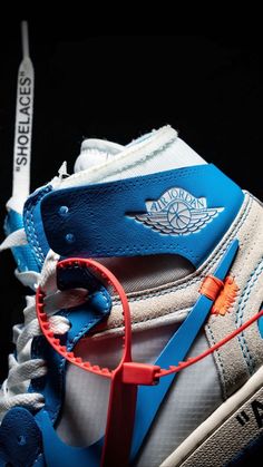 a pair of blue and white sneakers with red string attached to the shoelaces