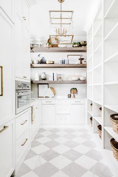 an image of a kitchen with white cabinets and open shelvings on the wall