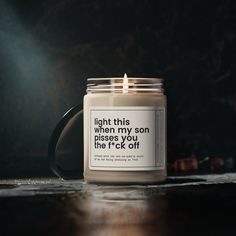 a candle with a quote on it sitting on a table next to a cup that says, light this when my son passes you like i'm ok