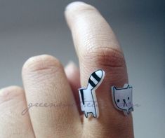 a person's hand with a cat ring on it