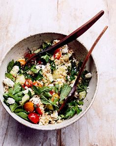 a bowl filled with salad and chopsticks on top of a wooden table