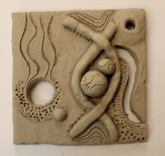 a sculpture made out of clay with two balls in it