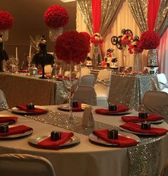 the table is set with silver and red place settings