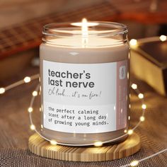 a candle that is sitting on a table with some string lights around it and the label reads teacher's last nerve