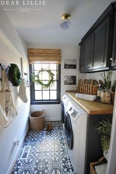 an image of a small laundry room with tile flooring and decor on the walls