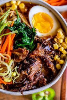 a bowl filled with noodles, meat and vegetables