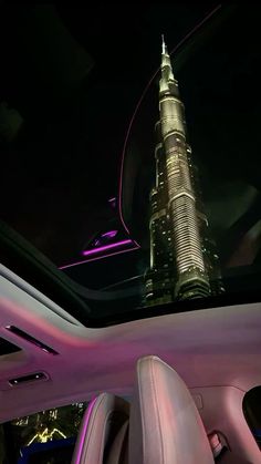 the interior of a car with an illuminated burj building in the background