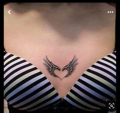 a woman's chest with an angel wing tattoo on her left side ribcage