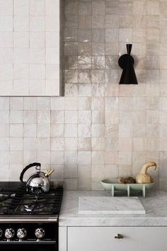 a stove top oven sitting inside of a kitchen next to a wall mounted faucet