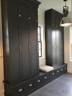 an empty room with black cabinets and drawers in the corner, along with a light fixture