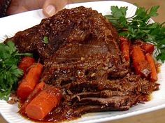 a white plate topped with meat and carrots