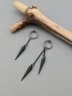 Clip-on spike earring, Black matte spike earring, Spike dangle, Spike gift, Gothic earring, Acrylic dangle, Black dangle, Matt black earring Two style spike earring with chain and clip-on hook.EAR DON'T HAVE TO BE PIERCED. 1. style earring with one chain total length 2,05 Inches ( 52 mm )         Spike charm length 0.9 Inches (22 mm ) 2. style earring with two chains total length   2,76 inches /7,0 cm/     The length of the longest chain 0,98 inches /2,5 cm/     The length of the shortest chain 0,39 inches /1,0 cm/         Spike charm length 0.9 Inches (22 mm )         Clip-on circle size 14 mm  Choose:1 of 2 hook style. Earring is really lightweight and comfortable to wear. It looks the same in both the right ear and the left ear. Modern and trendy earring NOTE: Delivery time to Europe is Punk Style Single Drop Earring, Punk Style Drop Earrings For Pierced Ears, Edgy Metal Plug Earrings, Punk Dangle Earrings For Party, Edgy Pierced Drop Earrings, Punk Style Drop Plug Earrings For Pierced Ears, Black Metal Cartilage Earrings For Party, Black Punk Jewelry With Spikes, Black Minimalist Plug Earrings