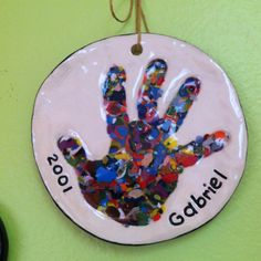 a ceramic ornament with a handprint on it that reads, 1001 galbrel