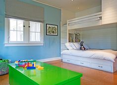 a child's bedroom with blue walls and green furniture