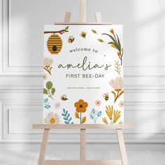 an easel with a sign that says welcome to amelie's first bee - day