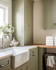 a white sink sitting under a window next to a wooden counter top in a kitchen