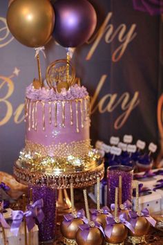 a purple and gold birthday cake on a table