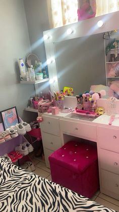 a bedroom with zebra print bedding and vanity area, mirror above the dresser has pink accessories on it