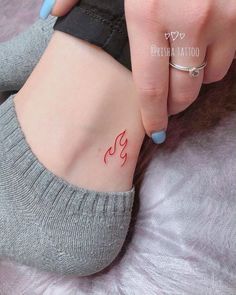 a woman's foot with a small tattoo on her left side and the word yoga written in red ink